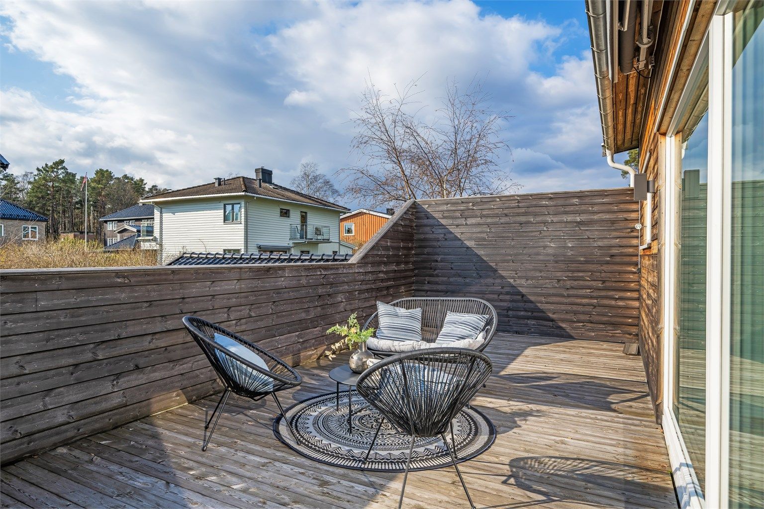 Uteplassen er skjermet med tett rekkverk i tre.