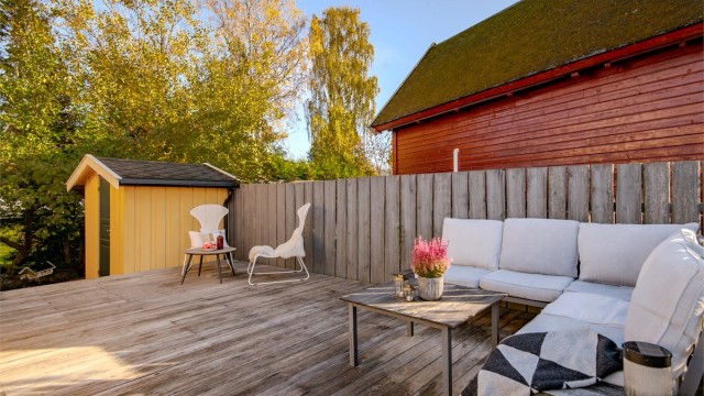 Stor markterrasse i tre med god plass til loungegruppe og spiseplass. Terrassen har sol fra morgen til kveld i sommerhalvåret, og vandrende skygge/sol resten av året.