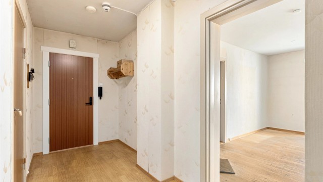 Entré med banebelegg på gulv, oppheng og adkomst til rommene.