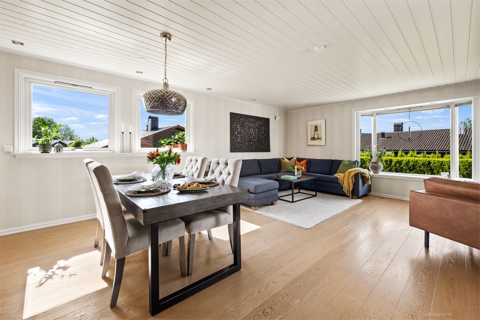 Stue med sofaområde, sittegruppe og spiseplass.
