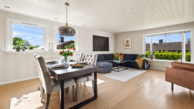 Stue med sofaområde, sittegruppe og spiseplass.