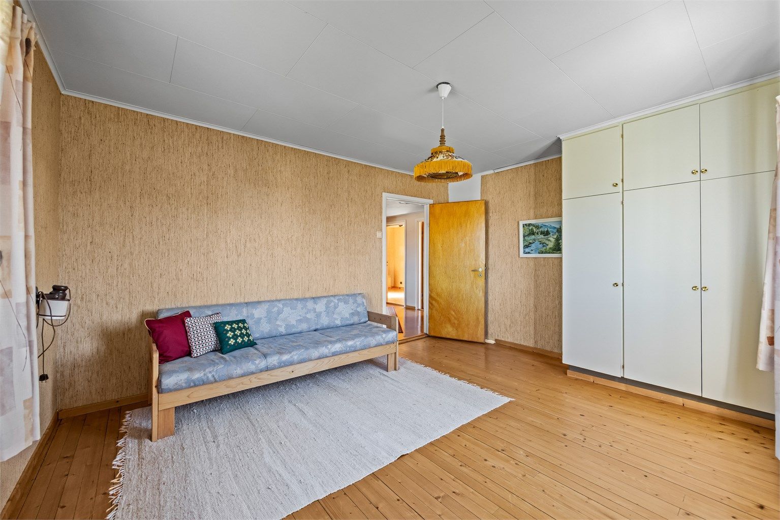 Soverom med tregulv og integrerte garderobeskap.