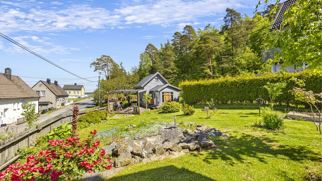 Her har man en fin hage med en frittstående bod og sitteområde.