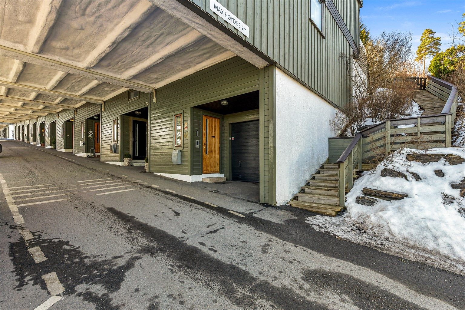 Inngangspartiet i 2.underetasje. Trappen fører opp til gangstien på oversiden med tilgang til markterrassen. Til venstre, utenfor bildet, er de to parkeringsplassene, i tillegg til garasjen.