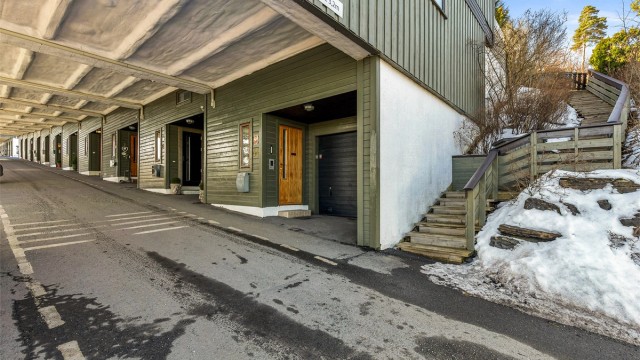 Inngangspartiet i 2.underetasje. Trappen fører opp til gangstien på oversiden med tilgang til markterrassen. Til venstre, utenfor bildet, er de to parkeringsplassene, i tillegg til garasjen.