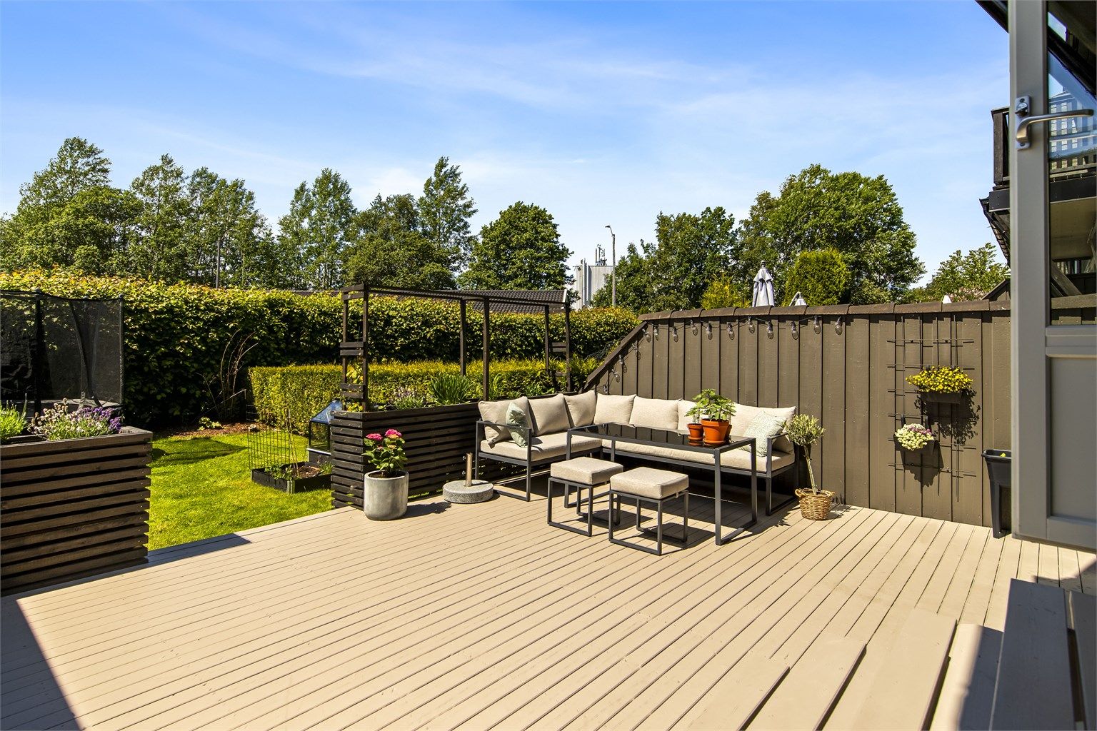 Rekkehus med stor, vestvendt terrasse og fasade med ny kledning og vinduer fra 2022.
Foto: Fotograf Magik