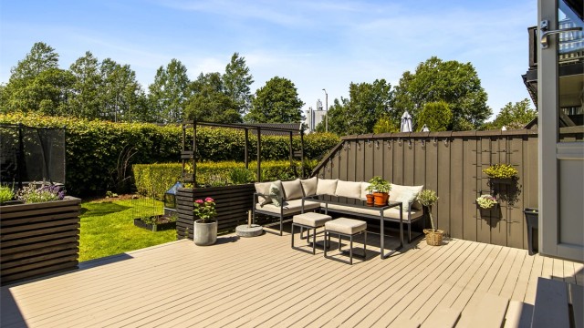 Rekkehus med stor, vestvendt terrasse og fasade med ny kledning og vinduer fra 2022.
Foto: Fotograf Magik