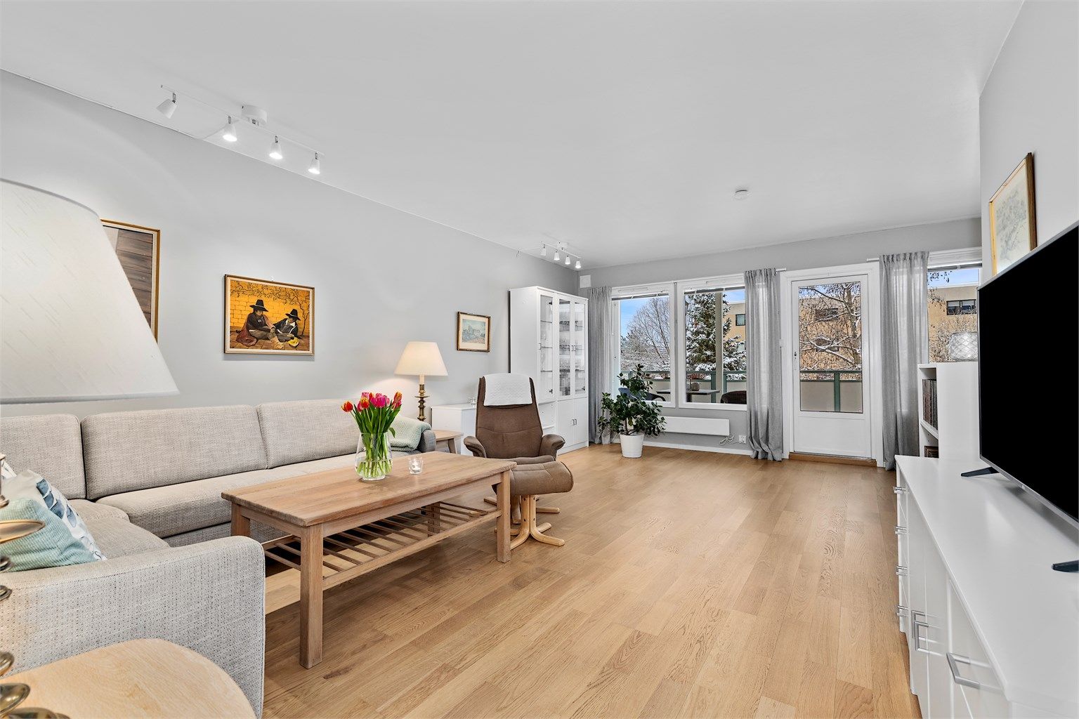 Romslig stue med direkte tilknytting til balkongen og spisestue delen.