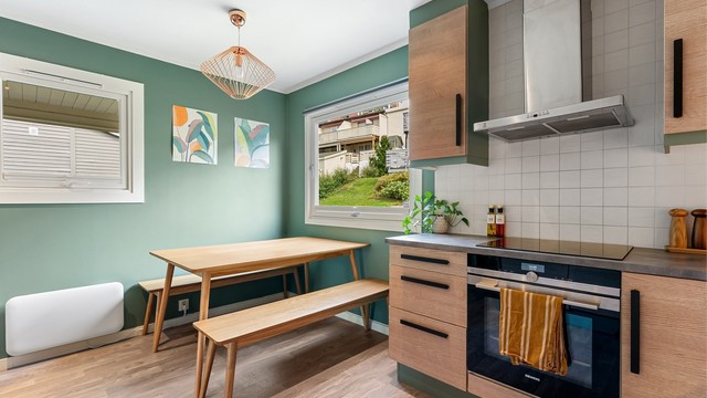 Kjøkkenet har spiseplass ved vinduet og en praktisk U-formet løsning med god skap- og benkeplass.