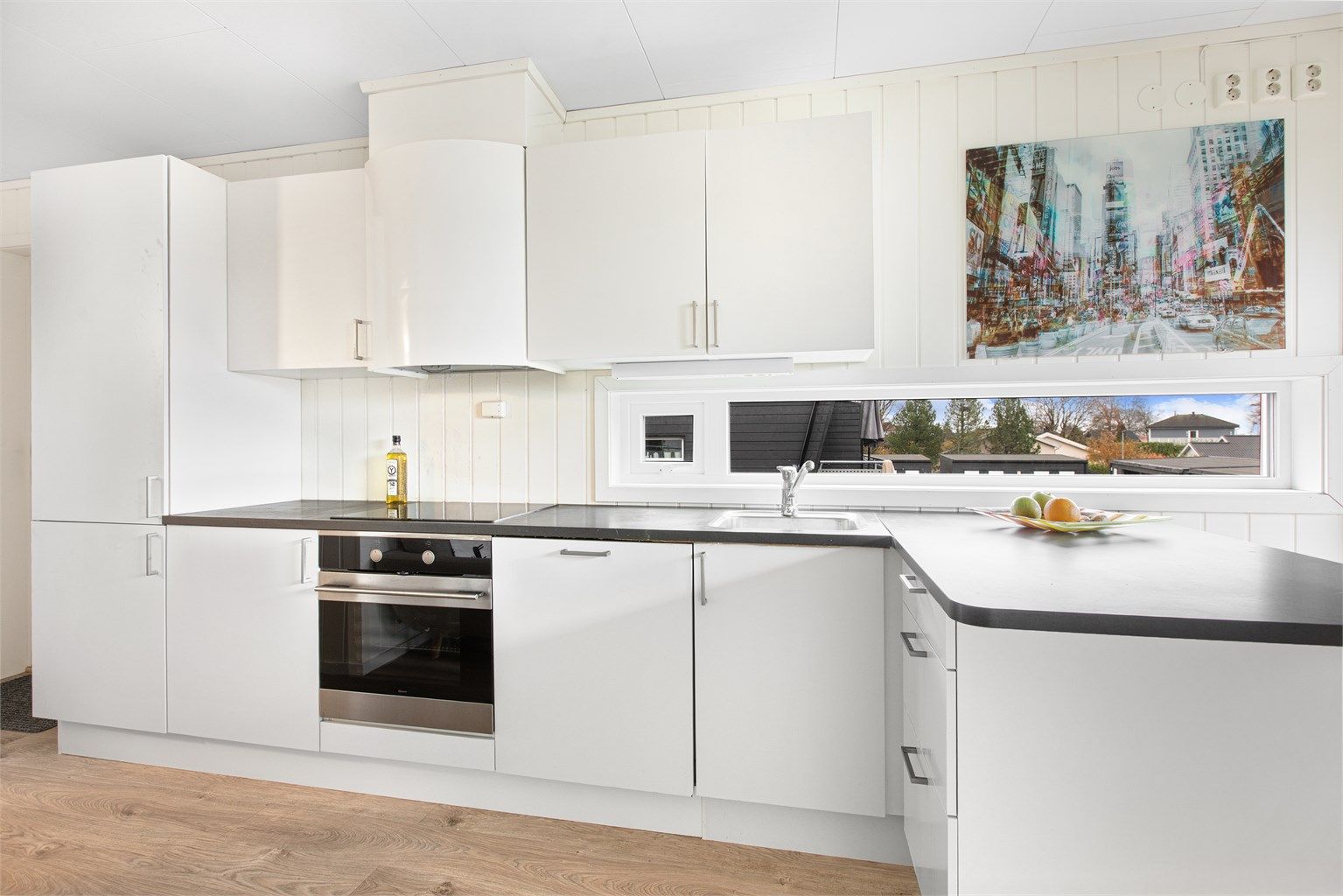 Åpen kjøkkenløsning mot stue med glatte fronter