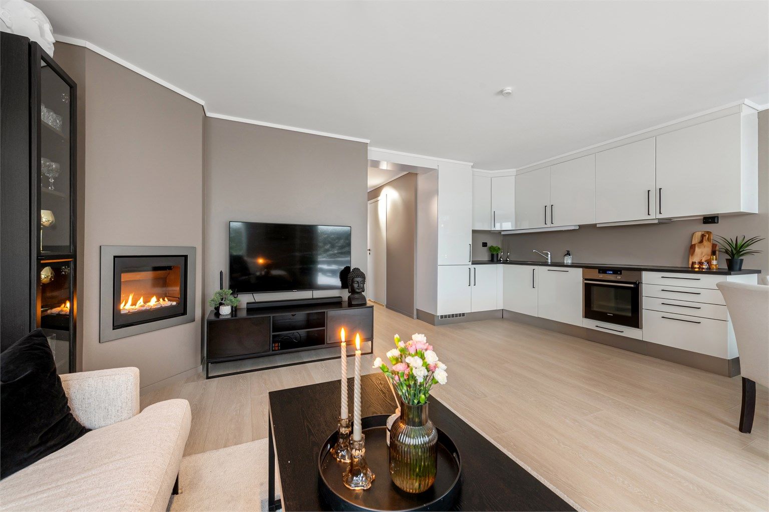 Den stemningsfulle gasspeisen i stuen gir en behagelig varme og atmosfære.