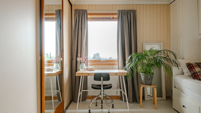 Romslig skyvedørsgarderobe med speildør og vindu som vender ut mot grønne omgivelser.