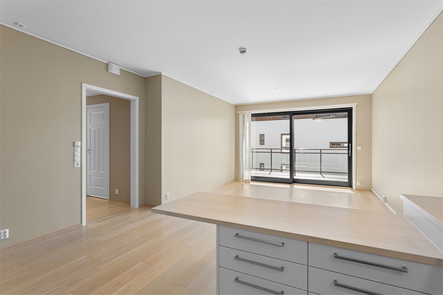 Fra kjøkkenet har du god oversikt over stuen og utgangen til balkong, samt gangen inn mot soverommene.