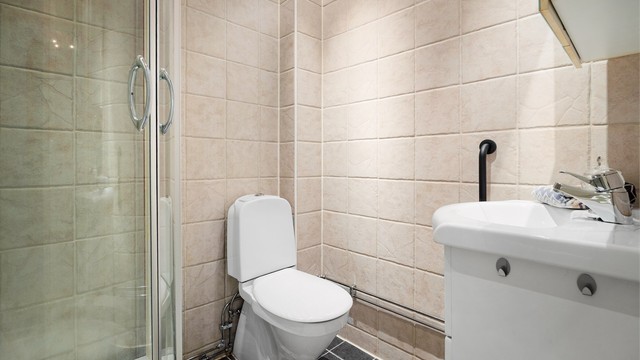 Badet er også innredet med servantinnredning med speilskap over.