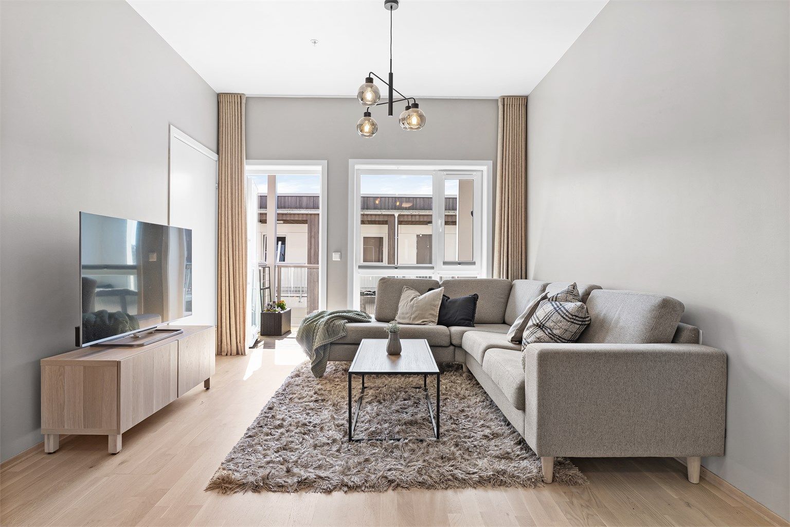 Det er gardinskinne i tak som skaper en sømløs overgang til gardinene og gir en eksklusiv følelse. Videre er det til venstre inngang til kontor/bod. 