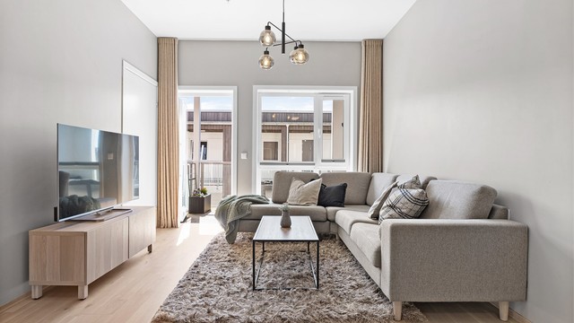 Det er gardinskinne i tak som skaper en sømløs overgang til gardinene og gir en eksklusiv følelse. Videre er det til venstre inngang til kontor/bod.