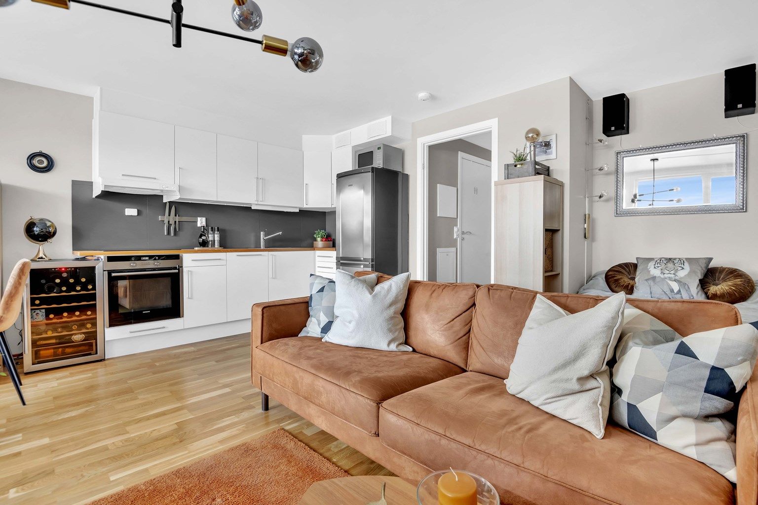 Åpen stue-kjøkken løsning med ønsket møblement som sofa, stuebord, tv og tv-benk.