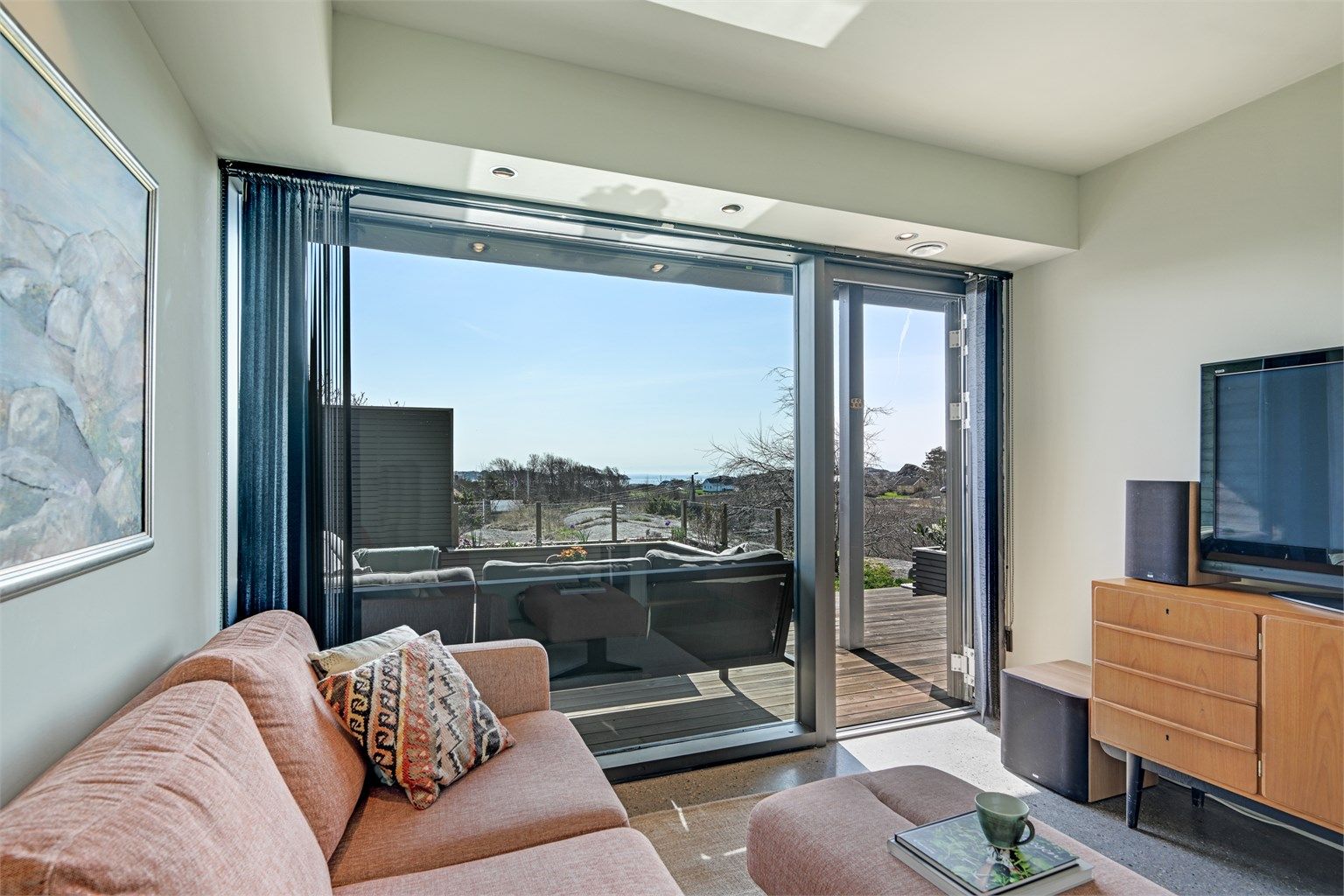 Også dette rommet har store vindusflater som visker ut skillet mellom inne og ute.