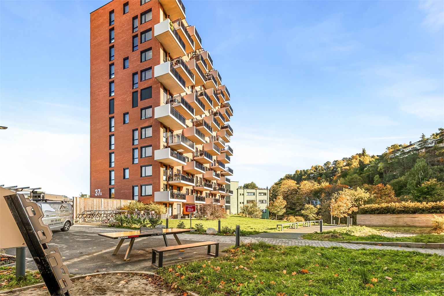 Moderne leilighetsbygg fra 2023 med teglfasade og grønne fellesarealer.
