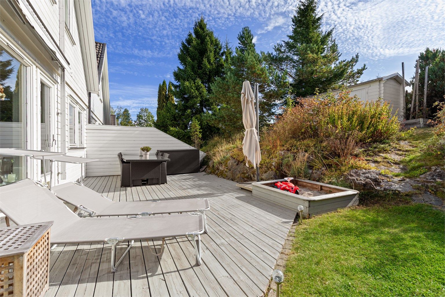 Stor markterrasse i trekonstruksjoner med god plass til solsenger og sittegrupper.