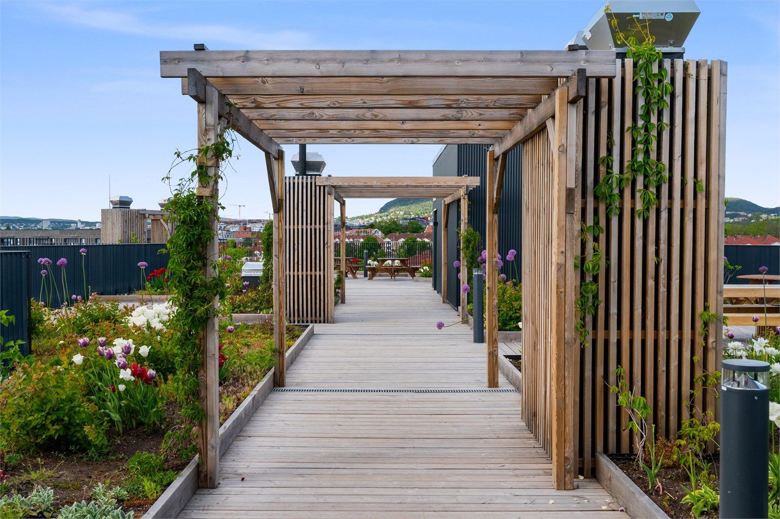 Takterrassen er flott opparbeidet med idylliske grøntområder og hyggelige sittegrupper.