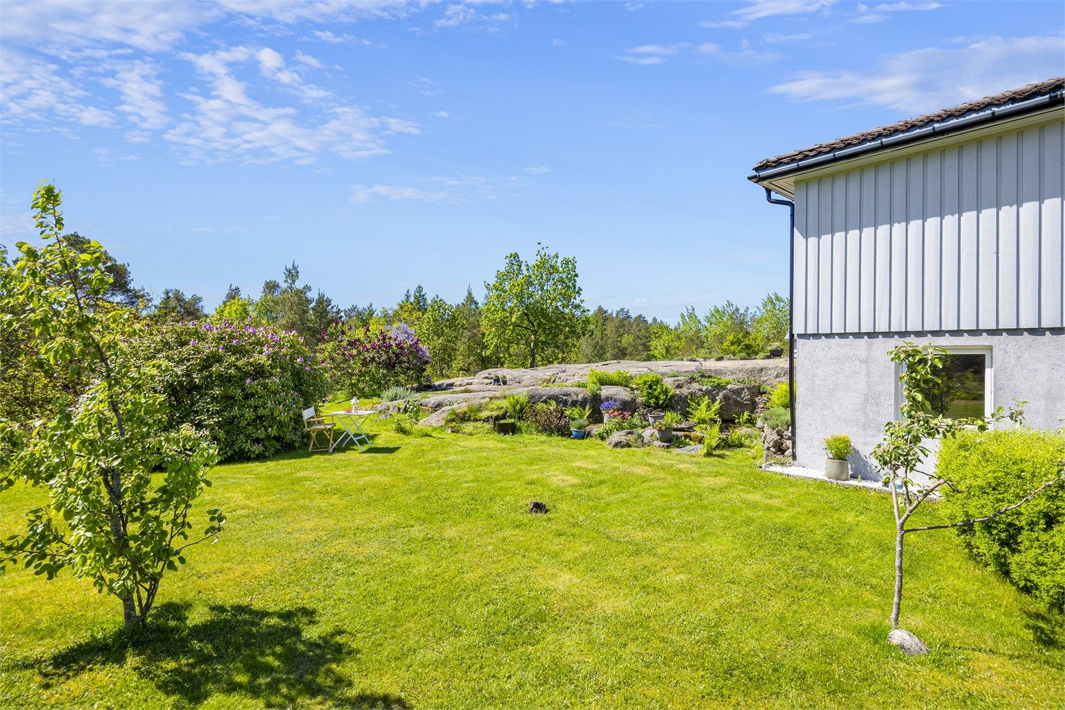 Tomten består av en kombinasjon av opparbeidet hage og naturtomt med svaberg.
