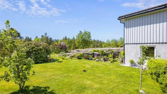 Tomten består av en kombinasjon av opparbeidet hage og naturtomt med svaberg.