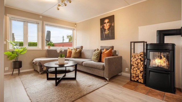 Lyse og delikate fargetoner gir stuen et lunt og harmonisk uttrykk, med peisovn og god plass til en stor sofagruppe.