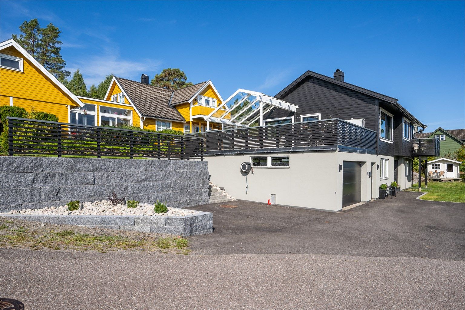 Terrenget er utnyttet på en god måte med støttemurer og terrengtrapp.Det er god plass til parkering.