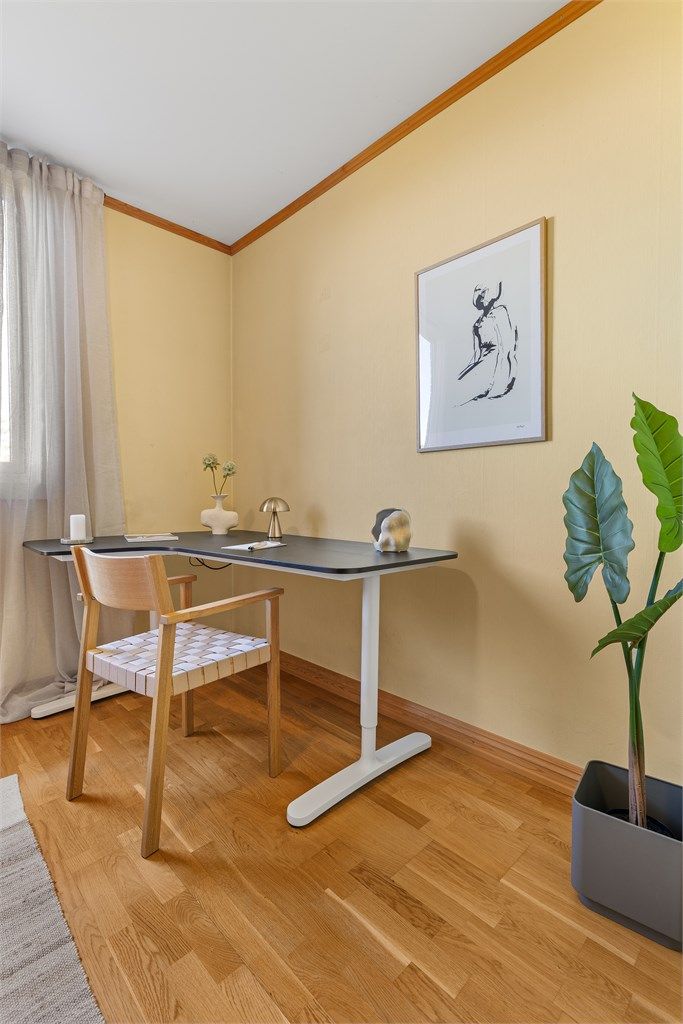 Praktisk arbeidsplass på soverommet med skrivebord og stol.