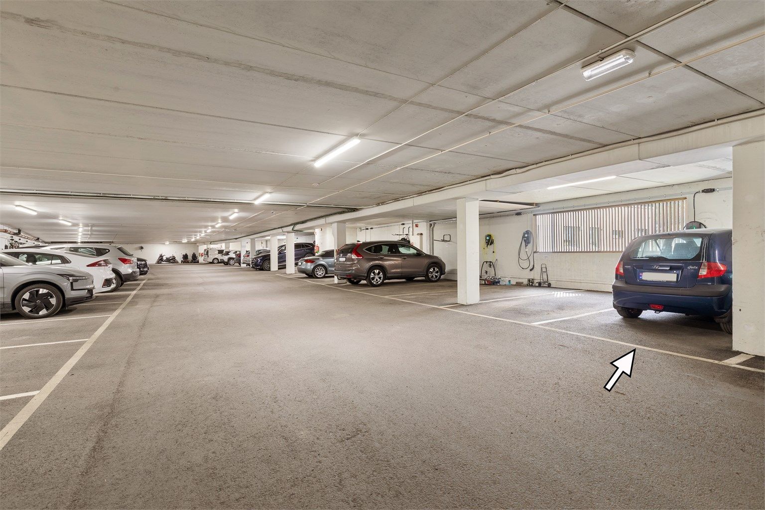 Garasjeplass i felles garasjekjeller. Mulighet for etablering av elbil-lader via borettslaget. Bekostes evt. av ny eier.