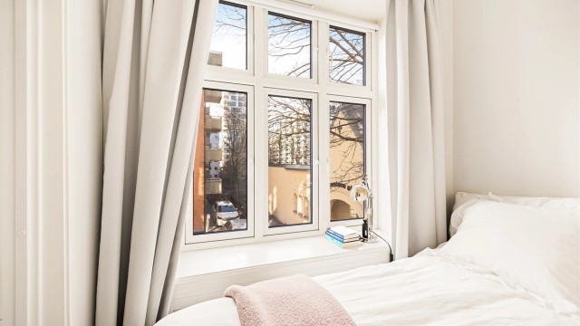Leiligheten har et separat rom benyttet som soverom med stort vindu, dør og plass til dobbeltseng.