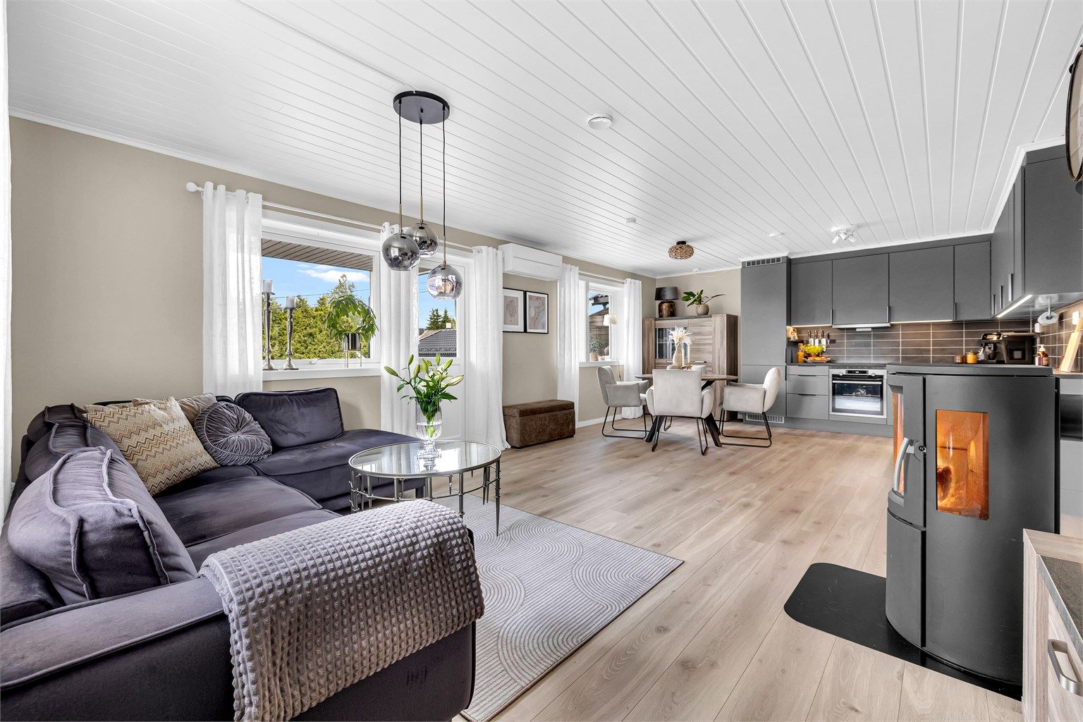 Stuen ligger i en åpen løsning med kjøkkenet, og sammen danner de et gjennomgående og innbydende allrom.