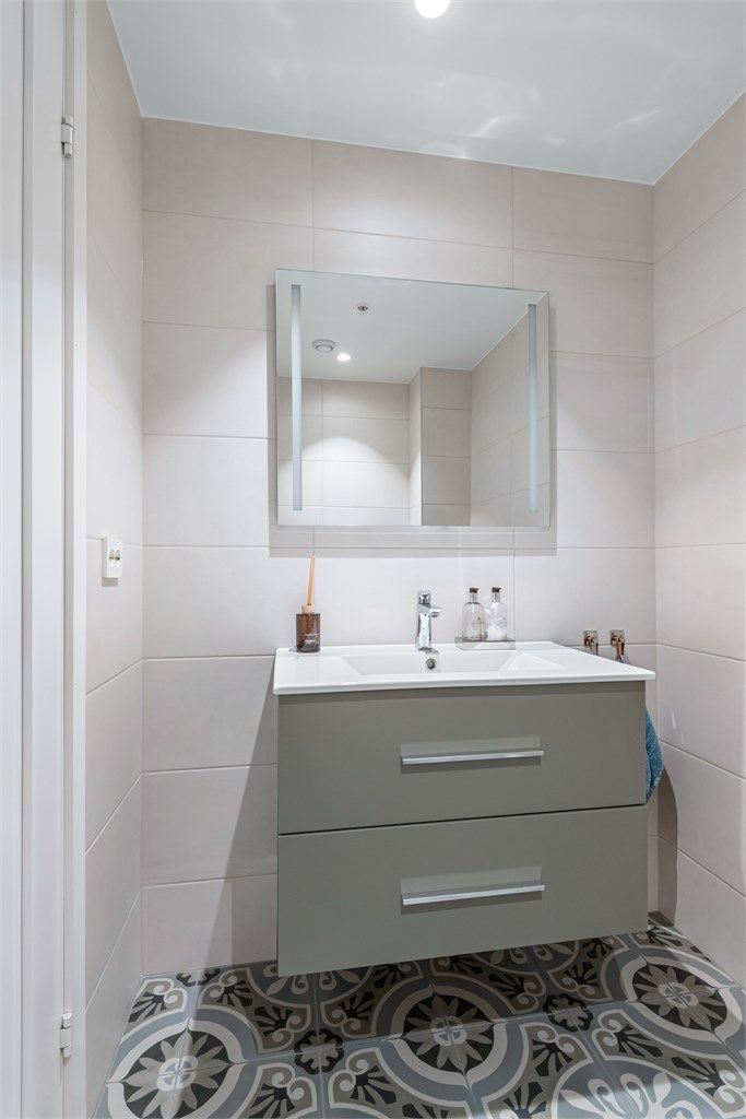 Servantinnredning og speil med sidelys på toalettrom