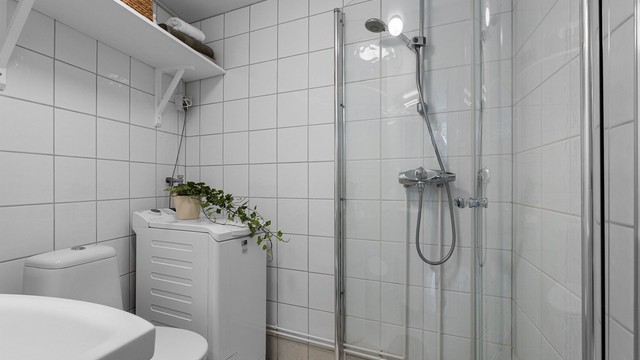 Flislagt bad med elektrisk gulvvarme og opplegg for vaskemaskin.