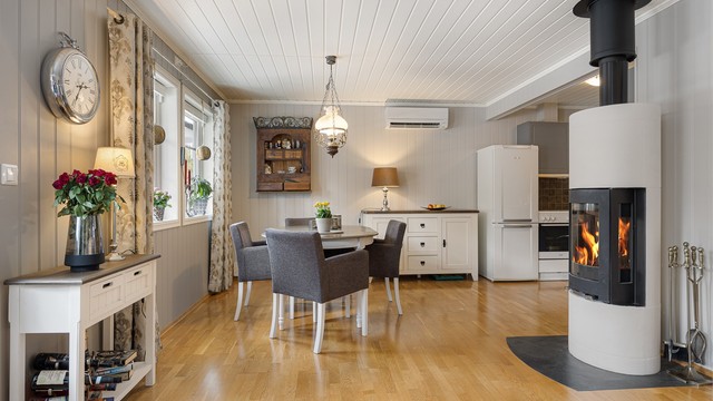 En frittstående peisovn med glass gir både varme og en hyggelig atmosfære. I tillegg er det installert en luft-til-luft varmepumpe fra 2020.