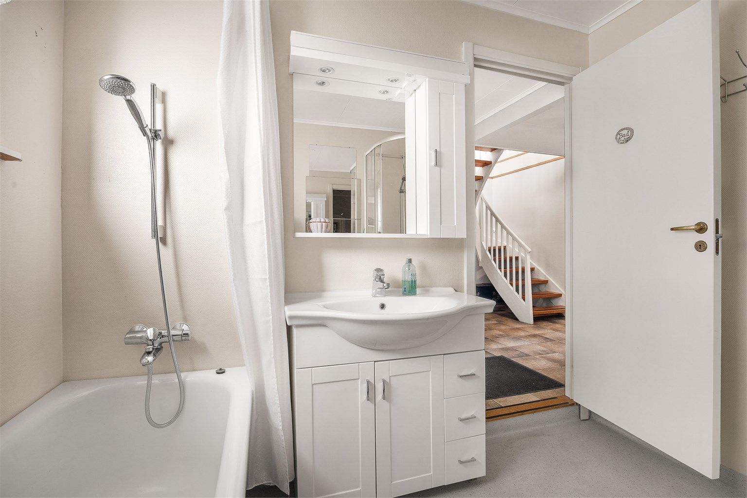 Varmekabler i gulv og servant med speilskap.