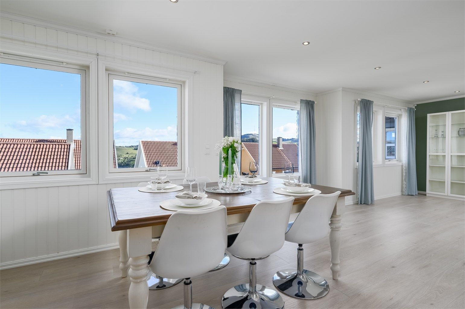 Spisestue mellom kjøkken og stue - store vindu som slipper inn rikelig med lys