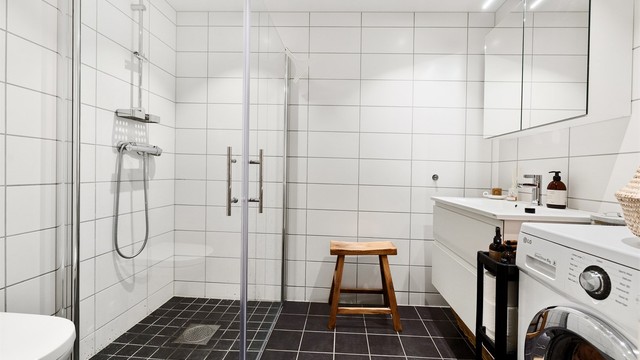 Moderne, flislagt bad fra 2023 med gulvvarme, downlights, vegghengt toalett og opplegg for vaskemaskin.