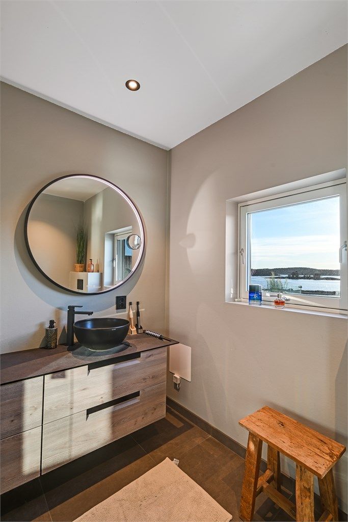 Rommet har innredning med servant, veggmontert "Geberit" dusjtoalett og dusjvegger/dør i glass inn til dusjsonen, hvor det er dobbel dusjløsning.