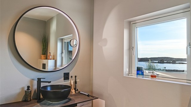 Rommet har innredning med servant, veggmontert "Geberit" dusjtoalett og dusjvegger/dør i glass inn til dusjsonen, hvor det er dobbel dusjløsning.