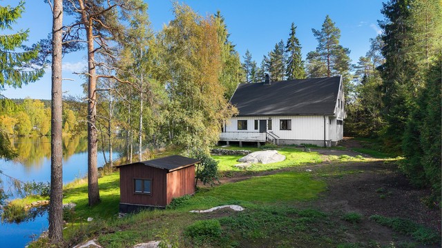 Tomten strekker seg helt ned til vannkanten og har to frittstående uteboder.