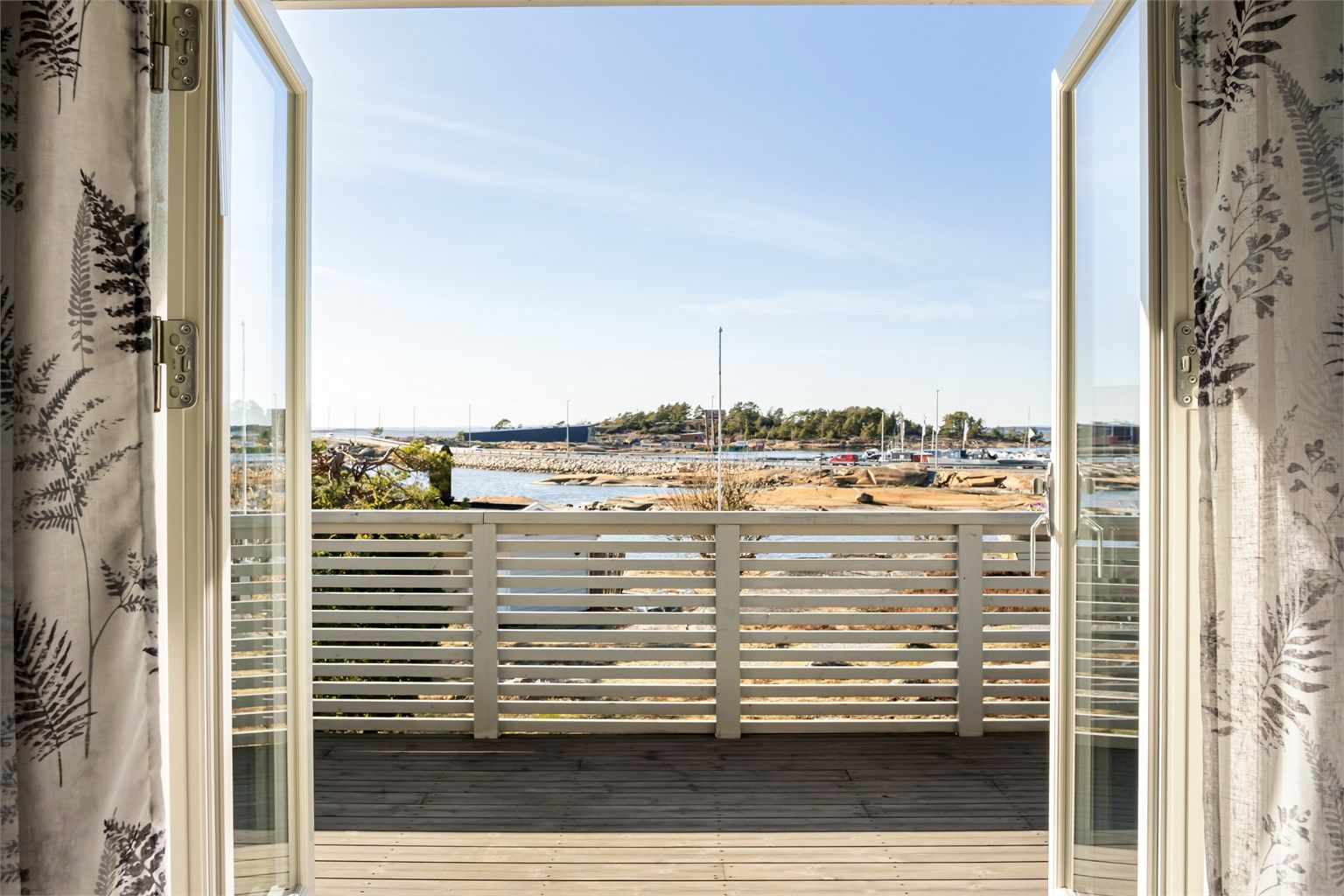 Terrassedøren bokstavelig talt åpner stuen mot utearealet og slipper havbrisen inn til stuen.