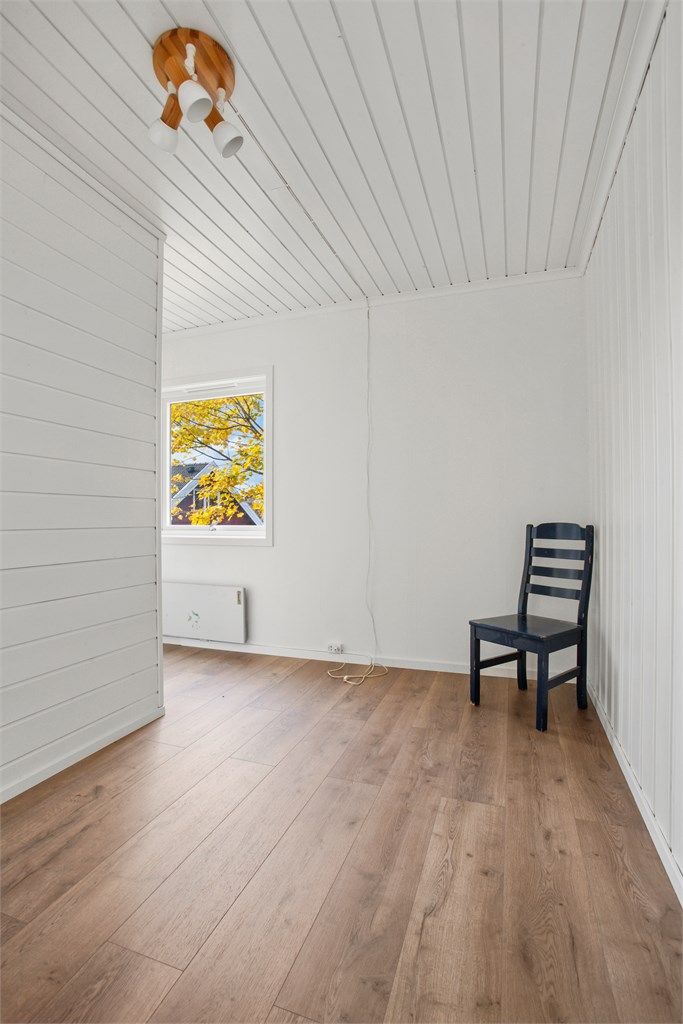 Lyst soverom med nytt gulv og utsikt mot hagen. 