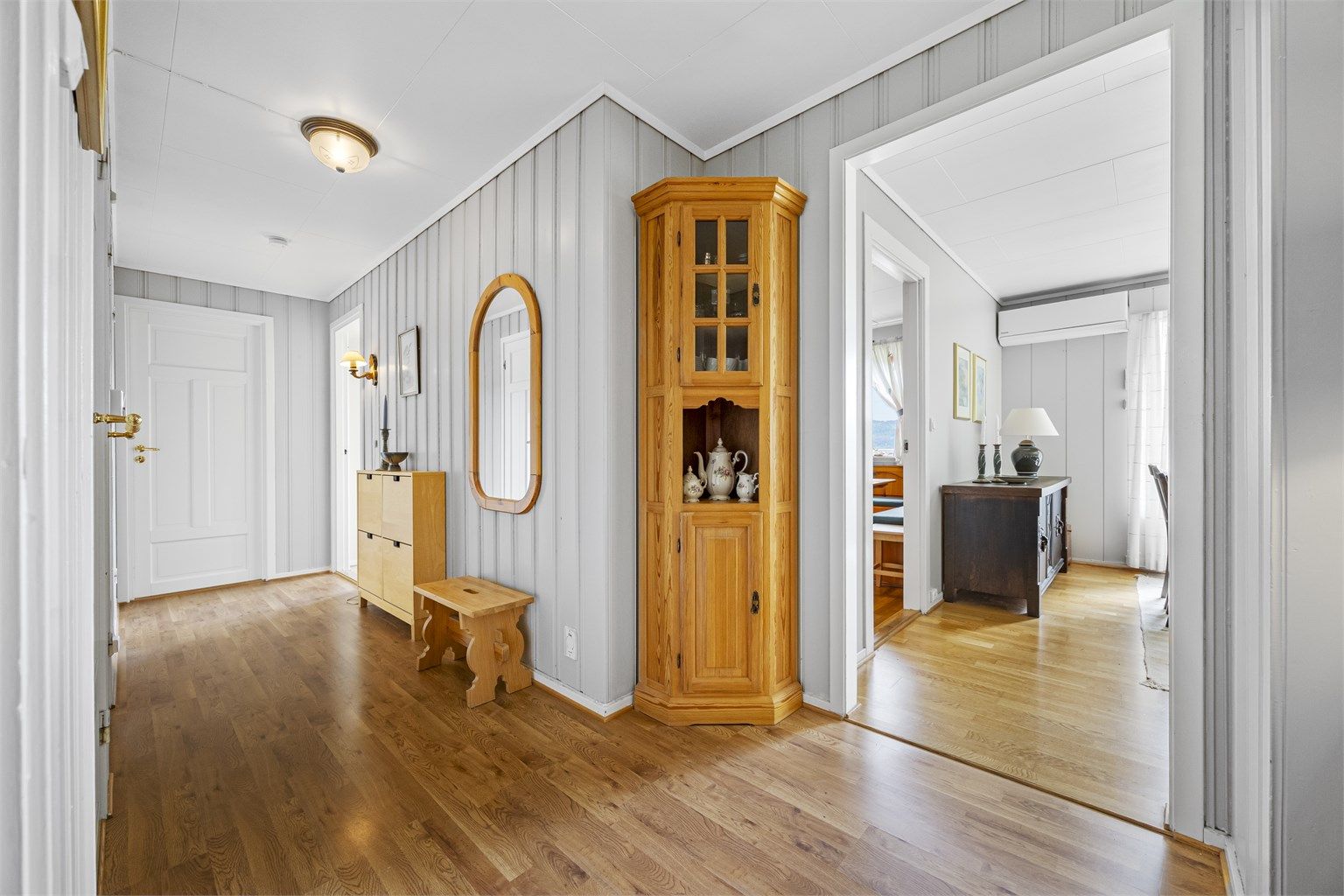 Romslig entré med laminat på gulvet og adkomst til stue og soveromsgang.