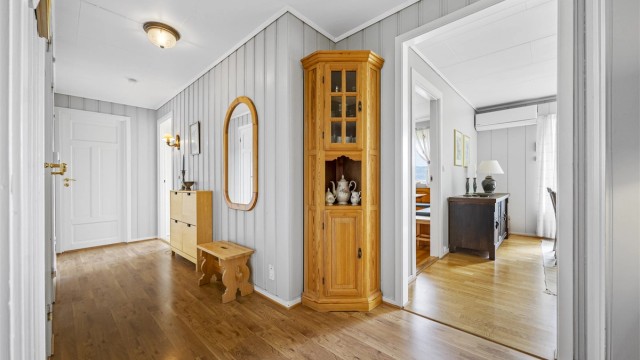 Romslig entré med laminat på gulvet og adkomst til stue og soveromsgang.