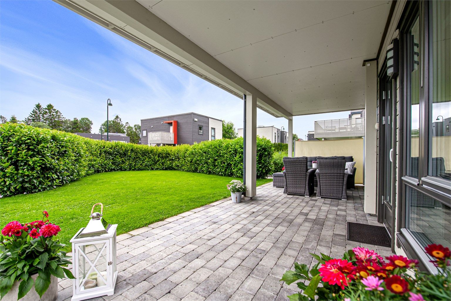 Overbygd steinlagt markterrasse med tilkomst til hage