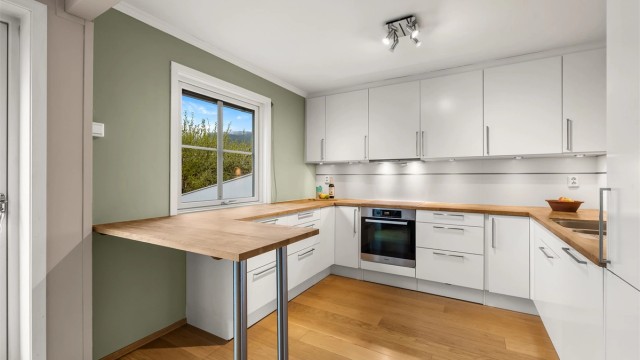 Kjøkkeninnredningen er fra HTH og har rikelig med skap- og benkeplass.