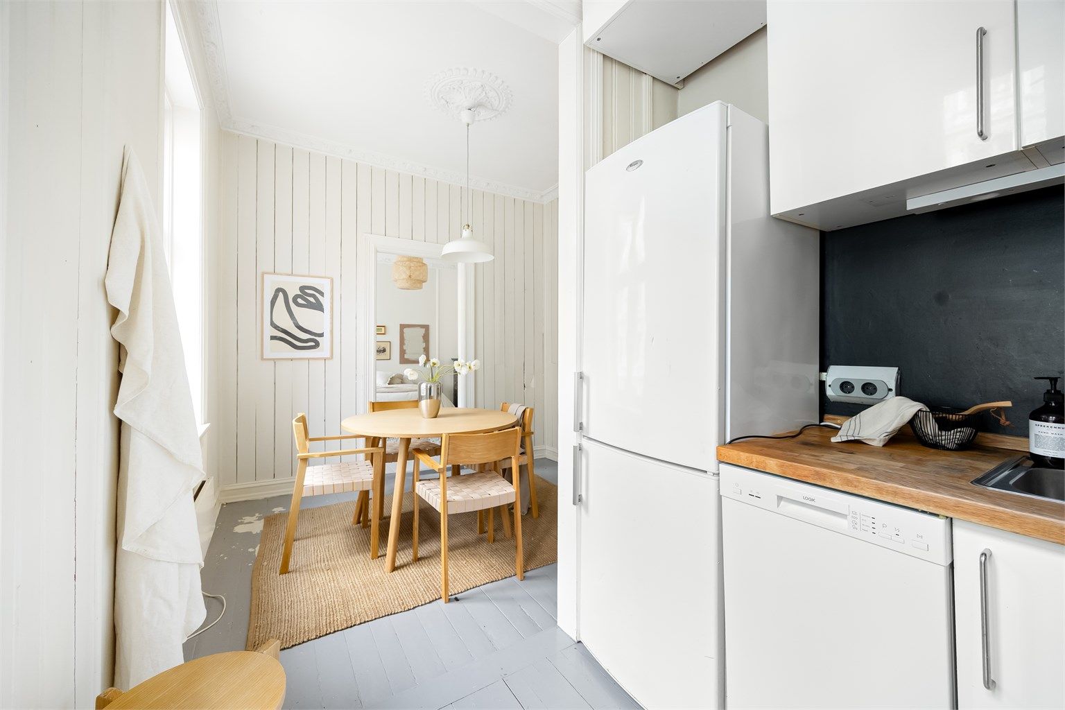 Kjøkkenet er utstyrt med integrerte hvitevarer som induksjonsplatetopp i benkeplaten, stekeovn og 45cm oppvaskmaskin, samt frittstående kjøleskap med fryser.