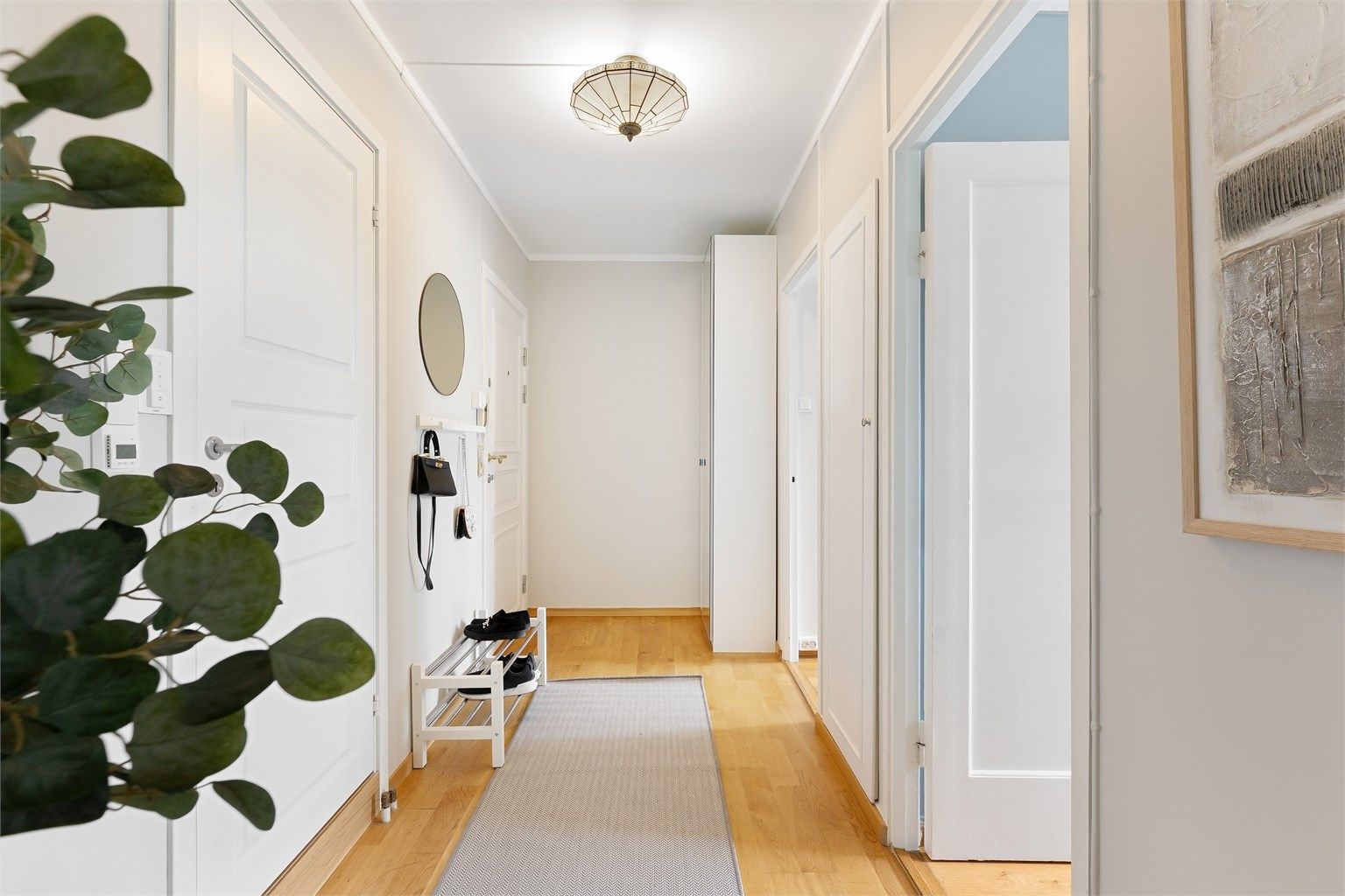 Innbydende entré med parkett på gulv og plass til garderobeskap.